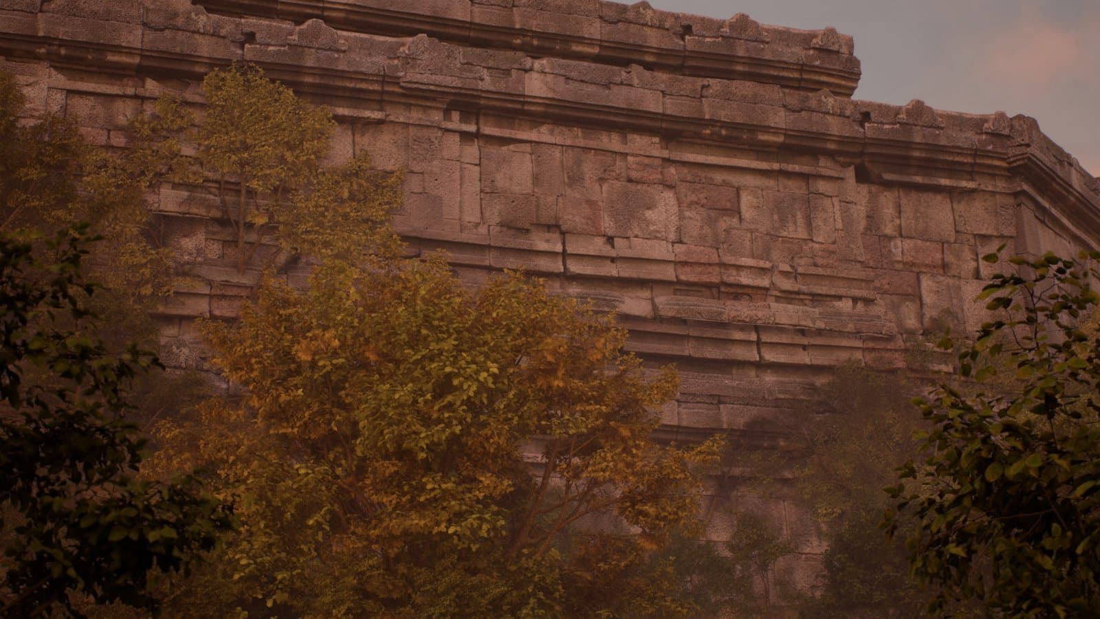 A coursed stone revetment wall rising above trees in haze
